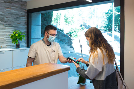 Woman paying for health or beauty treatment at the reception desk.の写真素材