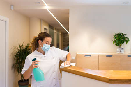 Young woman cleaning reception of physiotherapy centerの写真素材