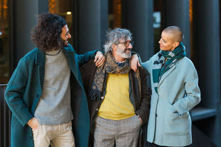 Business people looking at each other and smile while standing together outdoors on the street.の写真素材