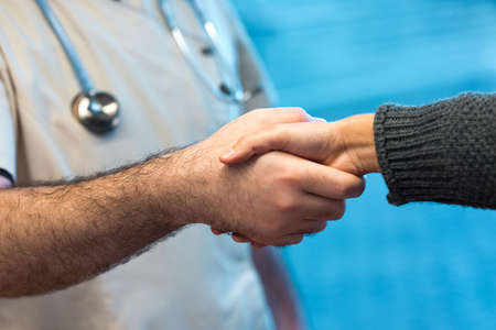 Doctor greeting client with handshake in hospitalの写真素材