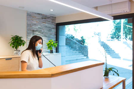 Receptionist speaking on phone at physiotherapy centreの写真素材