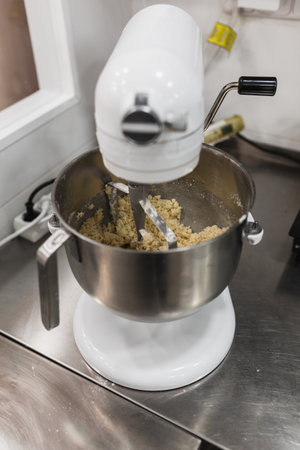 Electric mixer beating mixture in a pastry