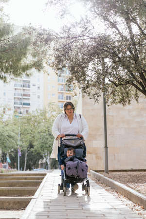 A mother walking her baby son in her stroller in the cityの写真素材