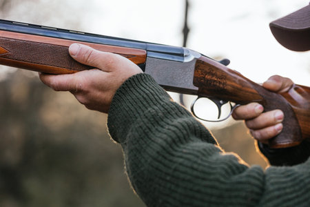 Man aiming rifle during hunting in nature