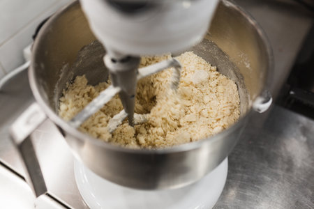Close up view of an electric mixer making dough in a bowl.の写真素材
