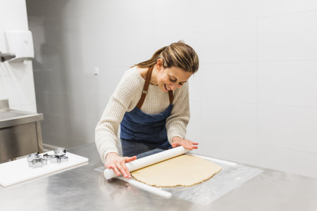 Cheerful cook kneading dough in pastry kitchenの写真素材