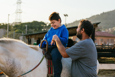 Smiley boy with cerebral palsy receiving equine therapyの写真素材