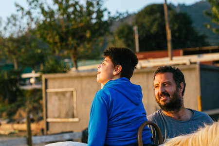 Child with disabilities enjoying riding a horse at equestrian center.の写真素材