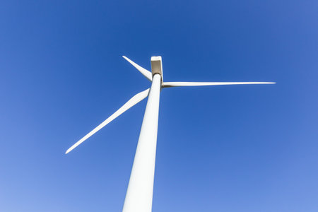 Renewable Energy Generation: Close-Up Shot of Wind Turbine against Blue Skyの写真素材