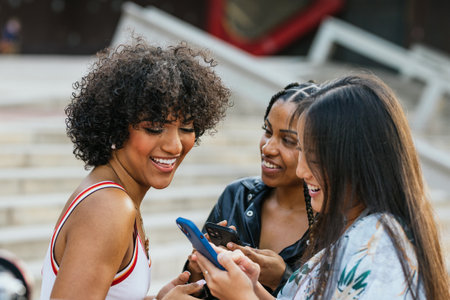 Multi-ethnic and multi-gender friends using phone in the streetの写真素材
