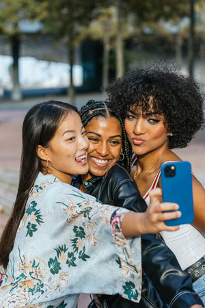 Happy multi-ethnic women and transgender person taking a selfie together
