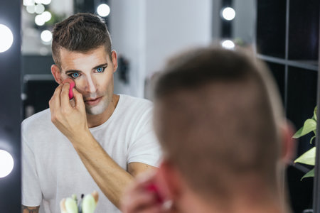 Gay man applying make up for a showの写真素材