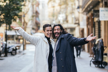Happy gay couple smiling and making funny face while posing outdoors in the street.の写真素材