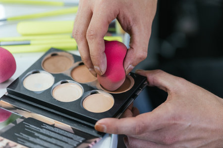 Close up view of a person holding makeup palette and sponge.の写真素材