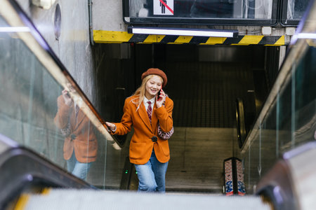 Asian woman talking on the phone while leaving the subway station.