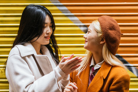 Asian lesbian couple smiling while enjoying time together outdoors.の写真素材