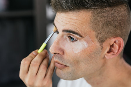 Close up view of a man putting on makeup.の写真素材