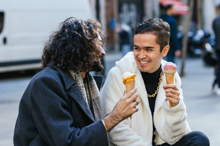 Happy gay couple enjoying eating ice cream outdoors.の写真素材