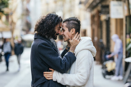 Affectionate male couple in love standing close to each other outdoors.の写真素材