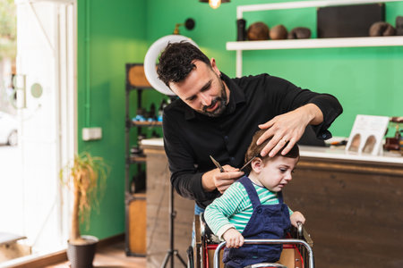 Professional barber giving a young child a haircutの写真素材
