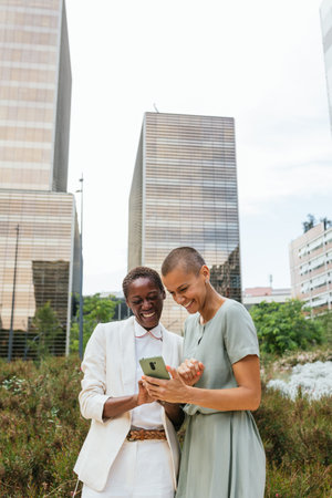 Image with copy space of two businesswomen looking happily at a phone.の写真素材
