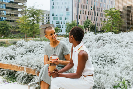 Two women enjoying coffee outdoorsの写真素材