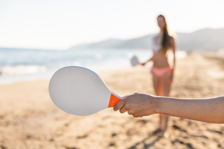 Beach paddle ball game at sunsetの写真素材