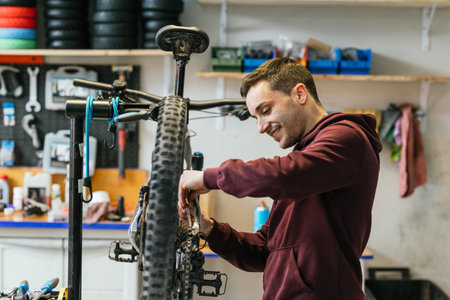 The bike mechanic is changing the chain of a bicycle in his workshop.の写真素材