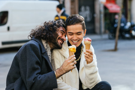 Happy gay couple enjoying ice cream together in the cityの写真素材