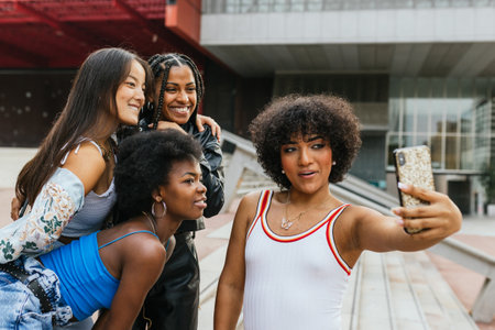 Latin woman takes selfie with her girlfriends on building stairs in the city.の写真素材