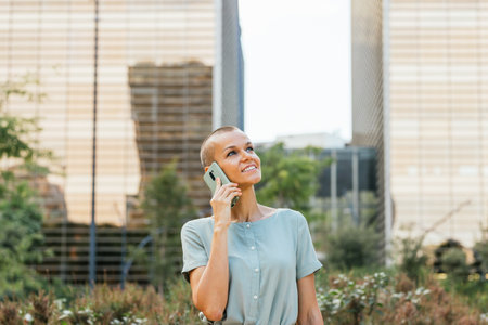 Smiling Woman On Phone Call Outdoors in Urban Parkの写真素材