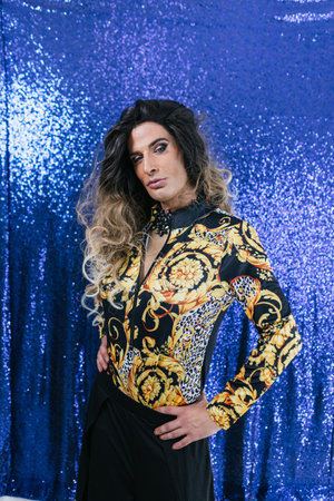 Confident drag queen posing against sequin backdropの写真素材