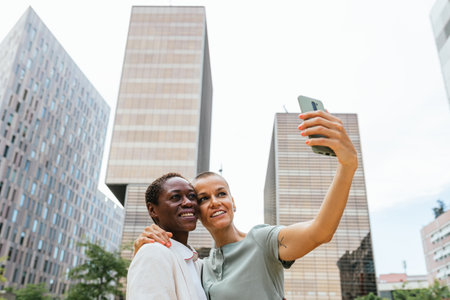 Urban Selfie: Two Individuals Capturing a Moment Amidst the Cityscapeの写真素材