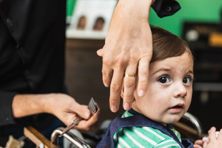 Little boys first haircut at barbershopの写真素材