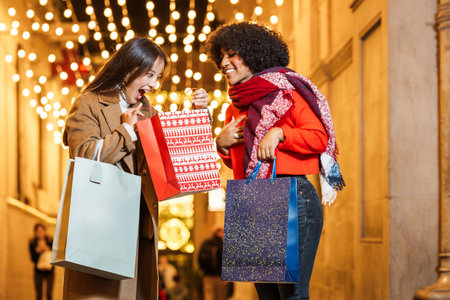 Two excited women showing gifts shopping for christmas presentsの写真素材
