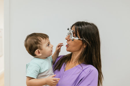 Female optometrist performing eye exam on toddler boy
