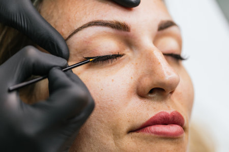 Professional makeup artist applying eyeliner on modelの写真素材