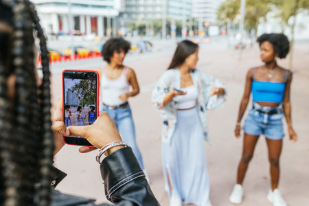 Woman recording friends dancing in urban environmentの写真素材