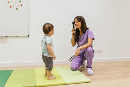 Optometrist examining vision of a baby boy in clinicの写真素材