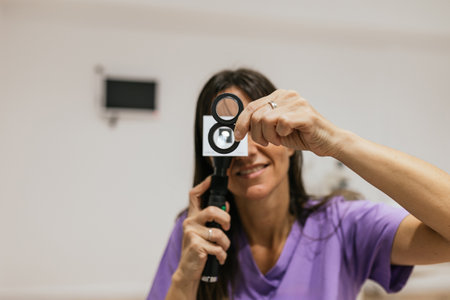 Optometrist performing retinoscopy exam using retinoscopeの写真素材