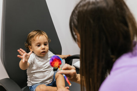Optometrist examining infants vision with colorful toyの写真素材