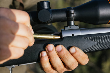 Hunter loading rifle with scope in forestの写真素材