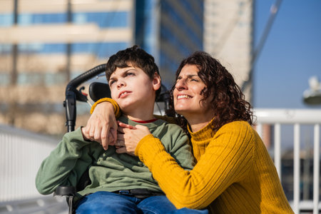 child with disability in wheelchair and mother looking to the future with hope