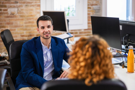 Businessman talking with coworker in modern officeの写真素材