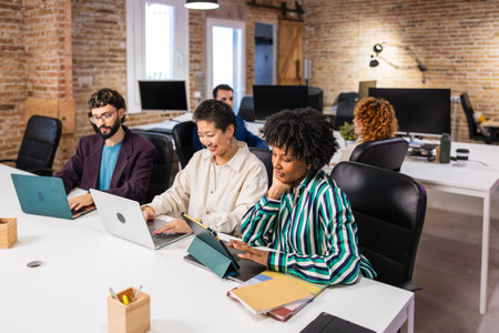 Multi ethnic team collaborating on project in modern office