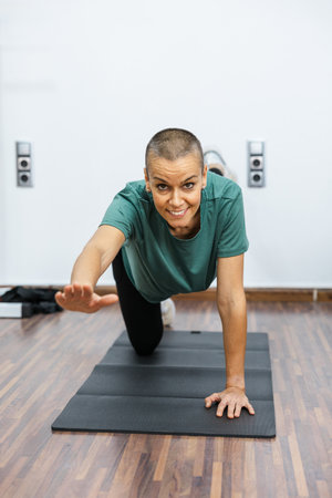 Woman performing bird dog exercise on yoga mat for core and abs workoutの写真素材