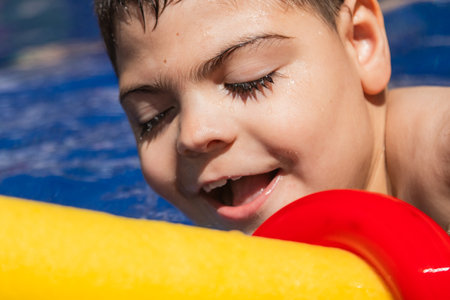 Child with cerebral palsy smiling and playing in swimming poolの写真素材