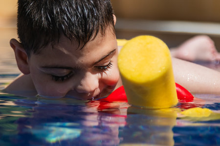Child with cerebral palsy swimming with floatation deviceの写真素材
