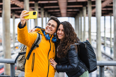 Happy tourists couple taking selfie at train stationの写真素材