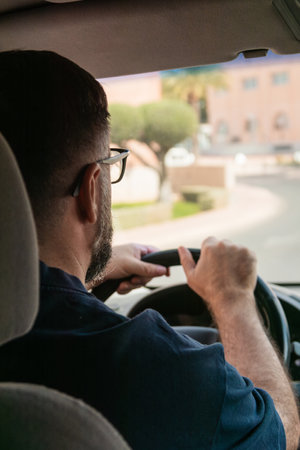 Man driving minivan on suburban street
